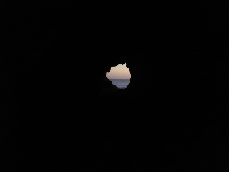 Looking through a rock cave at Leo Carillo State Beach in California.